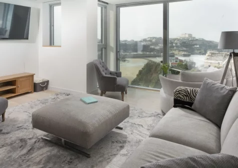 1 Island Reach, Newquay is a striking four-bedroom house moments from Towan Beach, featuring a sunset-view roof terrace, sleek open-plan living space, Juliet balconies over Newquay Bay and gated parking, perfect for unforgettable family holidays.