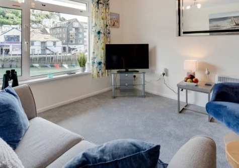 1 West Quay, Looe is a contemporary first-floor apartment on the waterside, offering couples gorgeous harbour views, elegant interiors flooded with light, and effortless access to Looe's sandy beach, harbourside restaurants, and coastal paths.