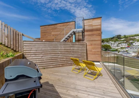 The decked terrace, barbecue & outdoor sitting area at 11 Beachdown, Challaborough