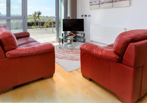 11 Zinc, Newquay is a stylish two-bedroom ground-floor apartment on Headland Road, just moments from Fistral Beach, boasting a golf-course view terrace, private balcony, underground parking, and easy access to Newquay's vibrant town centre.