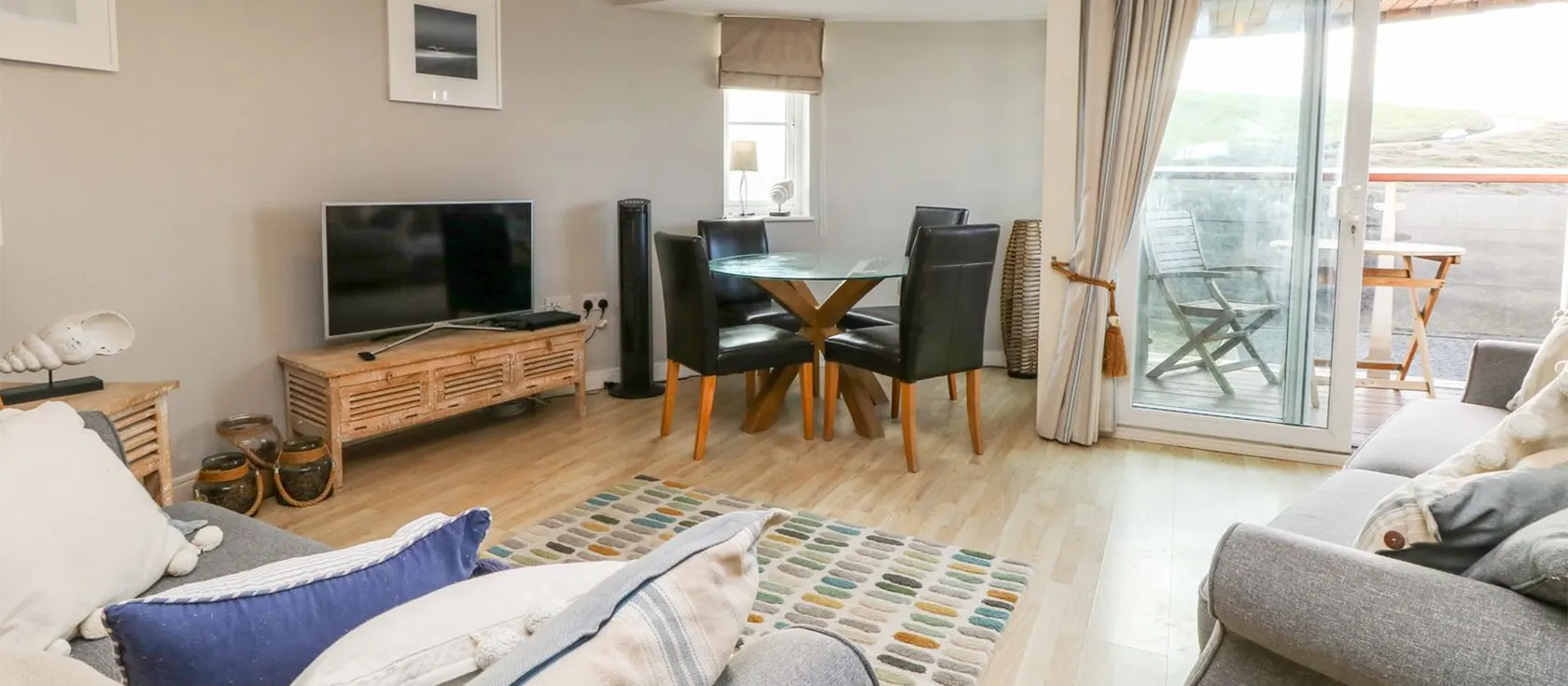 25 The Waves, Tregurrian is a modern two bedroom, two bathroom apartment on third floor with glass balcony & Watergate Bay views. Open floor plan with sofas, dining table & fully equipped kitchen with dishwasher. Parking. Walk to beach & restaurants.