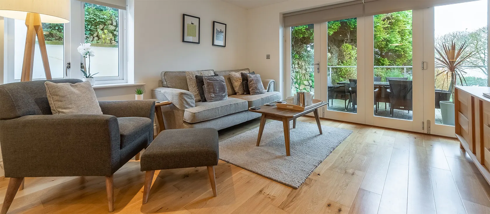 3 Sandy Lane, Carbis Bay is a luxurious ground-floor apartment with two double bedrooms, a modern bathroom and a spacious, open-plan living space. The flat has a large sea view balcony furnished with comfortable chairs and padded sun loungers.