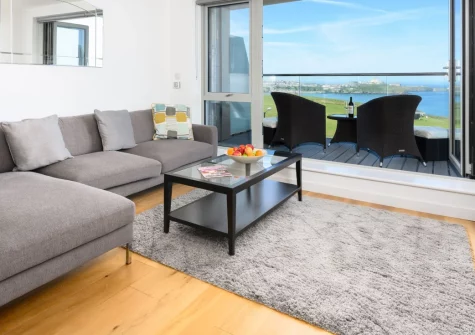 32 One Lusty Glaze, Newquay is a stylish three-bedroom apartment with sweeping sea views, a private balcony above Lusty Glaze Beach, underfloor heating throughout, and easy access to beaches, shops and coastal walks, perfect for family holidays.