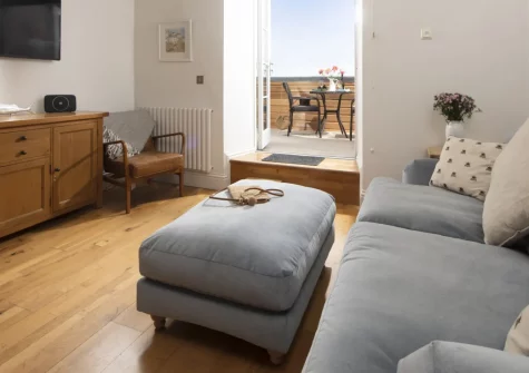 4 Fernhill, Carbis Bay is a charming ground-floor apartment with stunning sea views over St Ives Bay, a private decked balcony, and a garden path leading straight to Carbis Bay beach, ideal for peaceful, dog-friendly coastal getaways with loved ones.