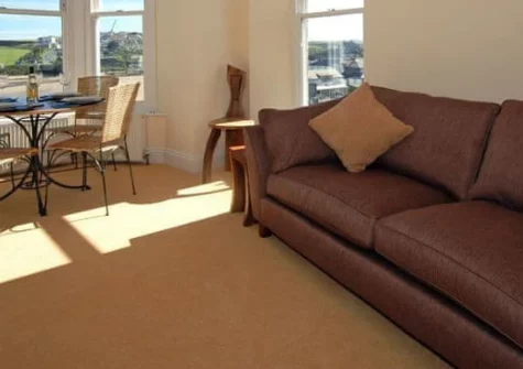 4 Seashore, Newquay is a beautifully appointed first-floor apartment directly overlooking Porth Beach, featuring exclusive steps to the sand, stunning sea views from the dining area, and contemporary interiors perfect for coastal living.