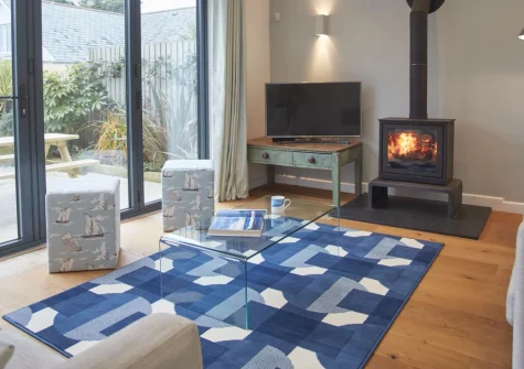 5 The Sands, Polzeath is a spacious four-bedroom coastal house with bi-fold doors opening onto a sunny garden and summerhouse, a cosy wood burner, and off-road parking, just a short stroll from Polzeath's famous surf beach and seafood restaurants.