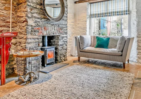 Amy Jane Cottage, Polruan is a characterful three-bedroom retreat in the heart of this picturesque harbour village, featuring exposed stone walls, stylish modern interiors, a cosy wood burner, and a sunny patio perfect for village watching.