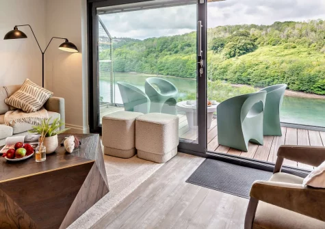 Annabell, Looe is a chic three-bedroom waterside retreat that is just 800 metres from Looe's harbour and beach, featuring a private hot tub, two balconies with stunning estuary views, sophisticated interiors, and designated parking.