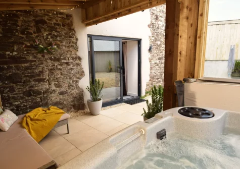The private hot tub, perfect for use in all weathers due to its unique enclosure, at Austen Cottage, Swanmoor Grange, Harracott
