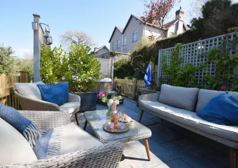 The enclosed tiered sun-trap patio & outdoor sitting area at Azalea Barn, Lee