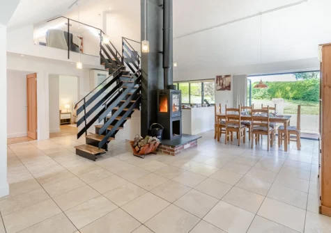 The dining area & stairs up to the galleried living area at Barn at Little Greenslade, Sampford Courteney