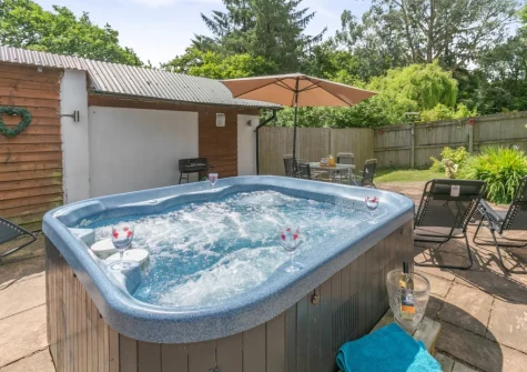 The patio, outdoor sitting area & hot tub at Barn at Little Greenslade, Sampford Courteney
