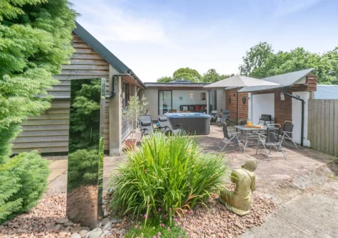 The patio, hot tub, barbecue & alfresco dining area at Barn at Little Greenslade, Sampford Courteney