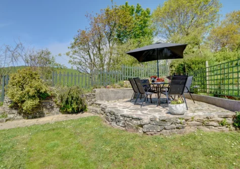 The tiered garden, patio & alfresco dining area at Bay View Bungalow, Combe Martin
