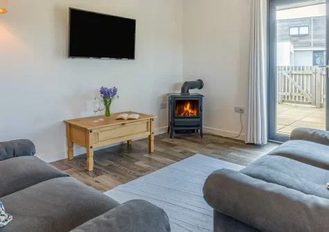 Beach Combers, Widemouth Bay is a light-filled coastal retreat less than a kilometre from golden sands, featuring stylish contemporary interiors, an enclosed sunny patio, and easy access to North Cornwall's dramatic coastline and surf beaches.