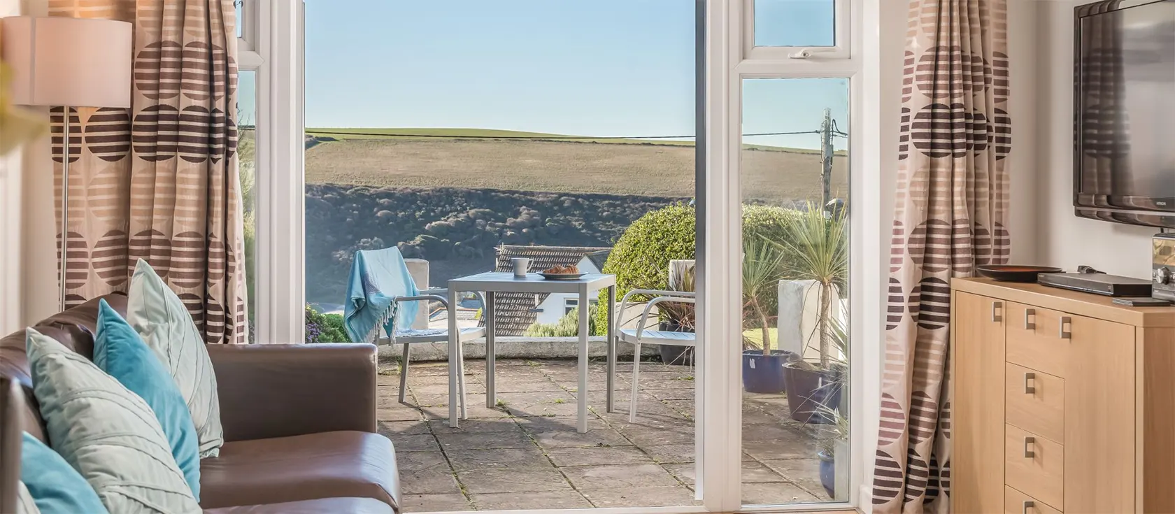 Beach View, Mawgan Porth is a one bedroom beach bungalow, tastefully furnished to sleep two-four guests. French doors in the living room open onto a private furnished terrace with rural views. Walk to beach & pub. Close to Watergate Bay Newquay.