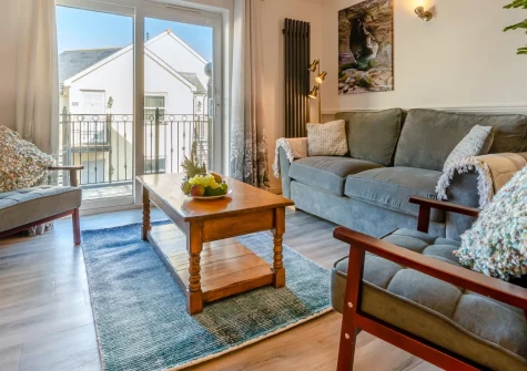 Beachcombers Retreat, Tregurrian is a bright two-bedroom apartment just 200 metres from Watergate Bay, with a sunny balcony, sea glimpses from the master bedroom, and easy access to Newquay's famous surf, golden sand and lively dining scene.