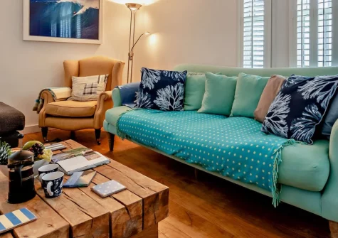 Beachside, Newquay is a stylish detached property just seconds from Fistral Beach, featuring contemporary coastal interiors, a wood burner, luxurious freestanding bath, enclosed garden, and beautiful sea views from the living room and bedroom.