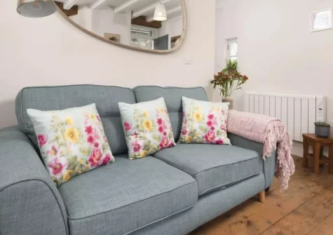 Berakah, Mousehole is a beautifully restored Grade II listed cottage moments from the harbour, with two en-suite bedrooms, a cosy log burner, sea glimpses from the master bedroom, and a sunny front terrace perfect for watching village life drift by.