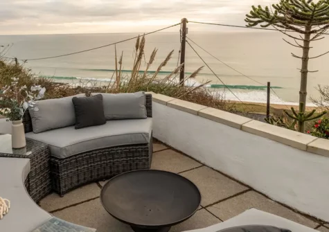 The paved terrace, outdoor sofa & fire bowl at Blue Yonder, Praa Sands