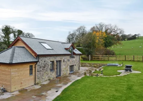 The patio, alfresco dining area, hot tub & enclosed garden at Bluebell Barn, Meldon