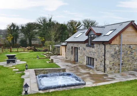 The alfresco dining area, hot tub & enclosed garden at Bluebell Barn, Meldon