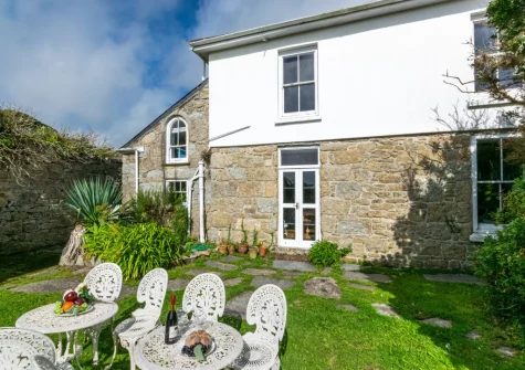 The outdoor sitting area & expansive manicured garden at Boslandew House, Mousehole