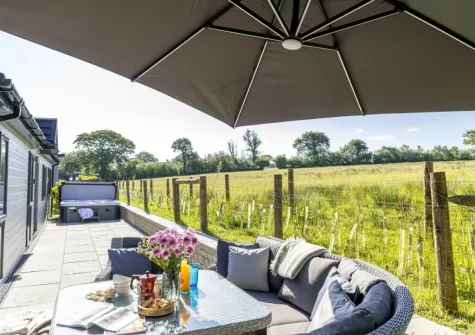 The patio, alfresco dining area & hot tub at Bramble Lodge, 12 Roadford Lake Lodges, Broadwoodwidger