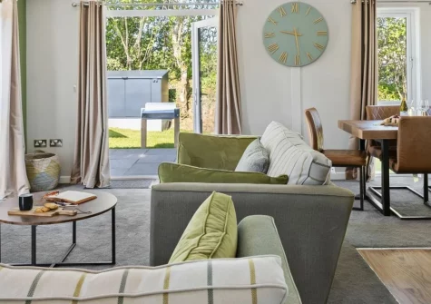Bramble Lodge, 12 Roadford Lake Lodges, Broadwoodwidger is a spacious three-bedroom retreat beside Devon's largest lake, featuring a private six-person hot tub, wraparound patio with field views, and direct access to woodland trails and water sports.
