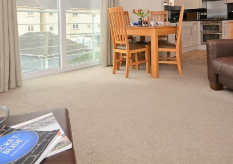 Bude's Cwtch, Bude is a contemporary first-floor apartment just moments from Crooklets Beach, featuring a bright Juliet balcony, modern coastal interiors with Smart TVs, and easy access to Bude's surf shops, restaurants, & spectacular coastal walks.