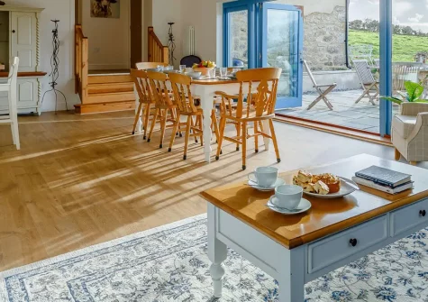 Butter Barn At Pengelly Farm, Nancegollan is a luxurious barn conversion nestled in the Cornish countryside with stylish interiors, bi-fold doors opening to farmland views, and perfect positioning to explore both North and South coast beaches.
