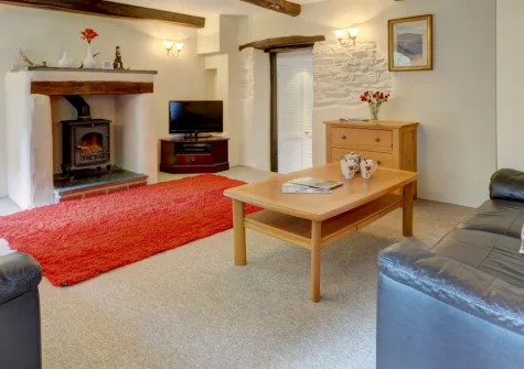 Button Stable, Bratton Fleming is a characterful stone barn conversion on a 60-acre working farm, featuring exposed beams, a cosy wood burner, three comfortable bedrooms, and shared gardens with access to neighbouring farmland for peaceful walks.