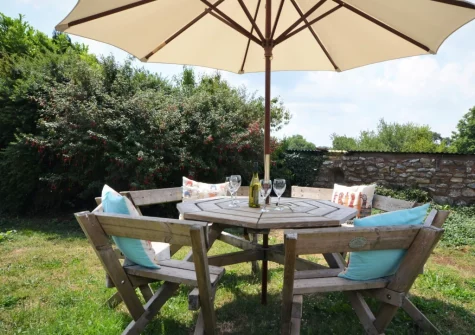 The enclosed lawned garden & alfresco dining area at Buzzard Cottage, Sheldon