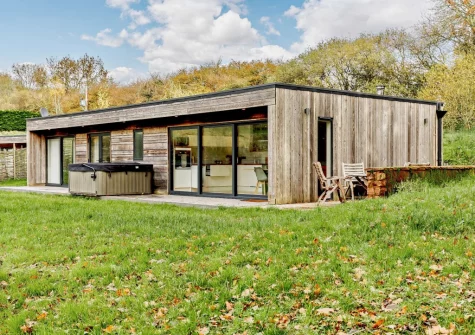 The patio, barbecue, alfresco dining area, hot tub & lawn at Cabana Lakeside Lodge 4, Whitnage