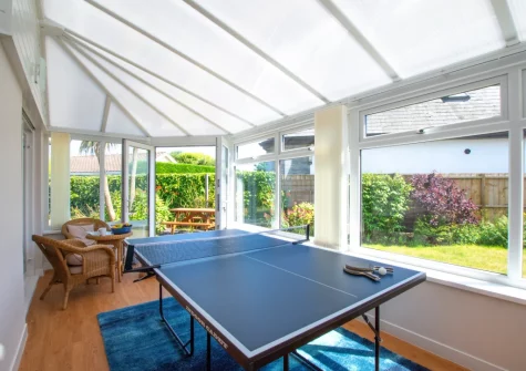 The sunny conservatory, with sitting area & table tennis, at Castaways, St Merryn
