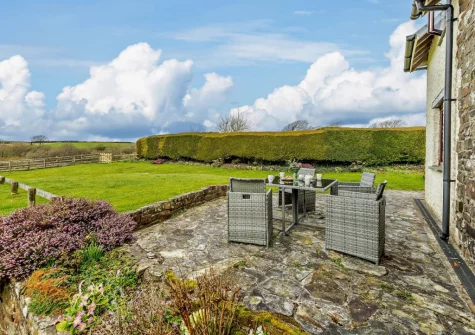 The patio, alfresco dining area & expansive garden at Cedar Cottage, Woolsery