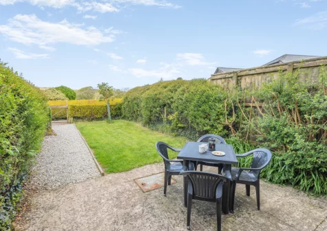 The patio, alfresco dining area & enclosed garden at Cherry Cottage at Mettaford Farm, Hartland