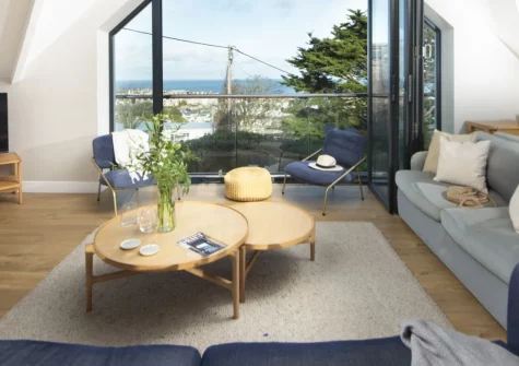 Cloud 10, St Ives is a stunning three-bedroom house with spectacular sea views, featuring a sun-trap balcony, enclosed garden with direct beach access, and contemporary interiors just moments from the harbour and fabulous golden sands.