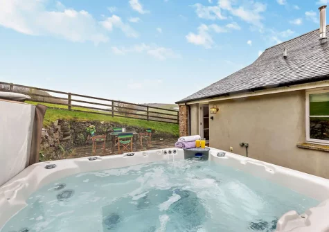 The patio, alfresco dining area & hot tub at Coach House At East Marsh Farm, North Molton