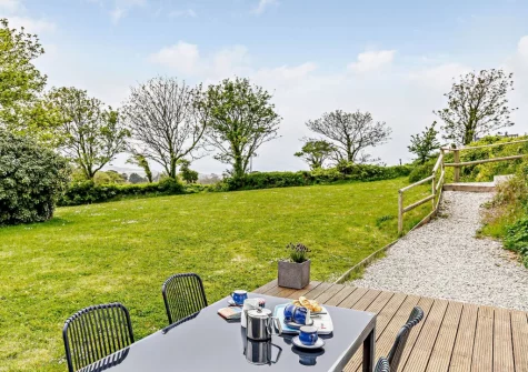 The decked patio, barbecue, alfresco dining area & enclosed garden at Crabbe Cottage, Poughill
