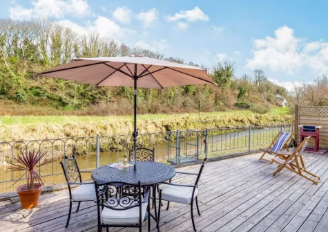 The decked terrace, barbecue, alfresco dining & outdoor sitting area at Creekside, Little Petherick