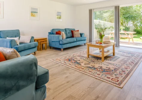 Crugmeer, St Merryn is a stunning contemporary three-bedroom house just a short stroll from award-winning dining, featuring a sunny garden with shaded areas, modern en-suite bedrooms, and easy access to North Cornwall's pristine sandy beaches.