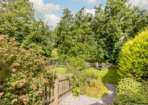 The riverside garden & outdoor sitting area at Dairy Cottage, Swimbridge