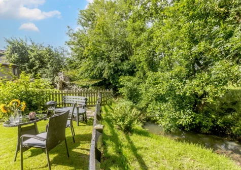 The riverside garden & outdoor sitting area at Dairy Cottage, Swimbridge