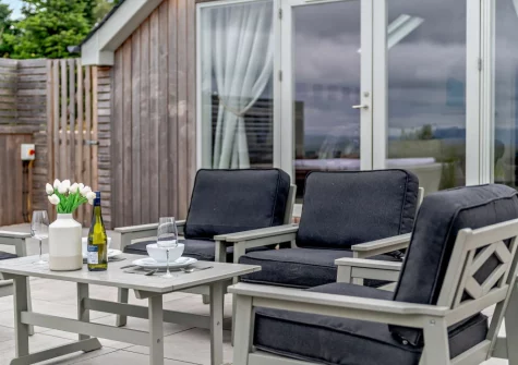 The patio, barbecue, outdoor sitting area & hot tub at Dartmouth Lodge, Marldon