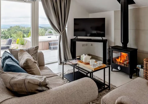Dartmouth Lodge, Marldon is an exquisitely styled one-bedroom couples' retreat nestled on a Christmas tree farm, complete with a private hot tub, sweeping countryside views, and effortless access to Devon's finest beaches, towns, and attractions.
