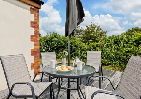 The decked patio with alfresco dining area at Deer Lodge, High Bickington