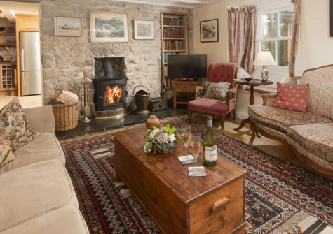 Deugh an Chy, Godolphin Cross is a spacious four-bedroom Cornish cottage set amid open countryside, featuring a cosy wood-burning stove, sunny terrace, and easy access to the Godolphin Estate and Cornwall's finest beaches, sleeping seven.