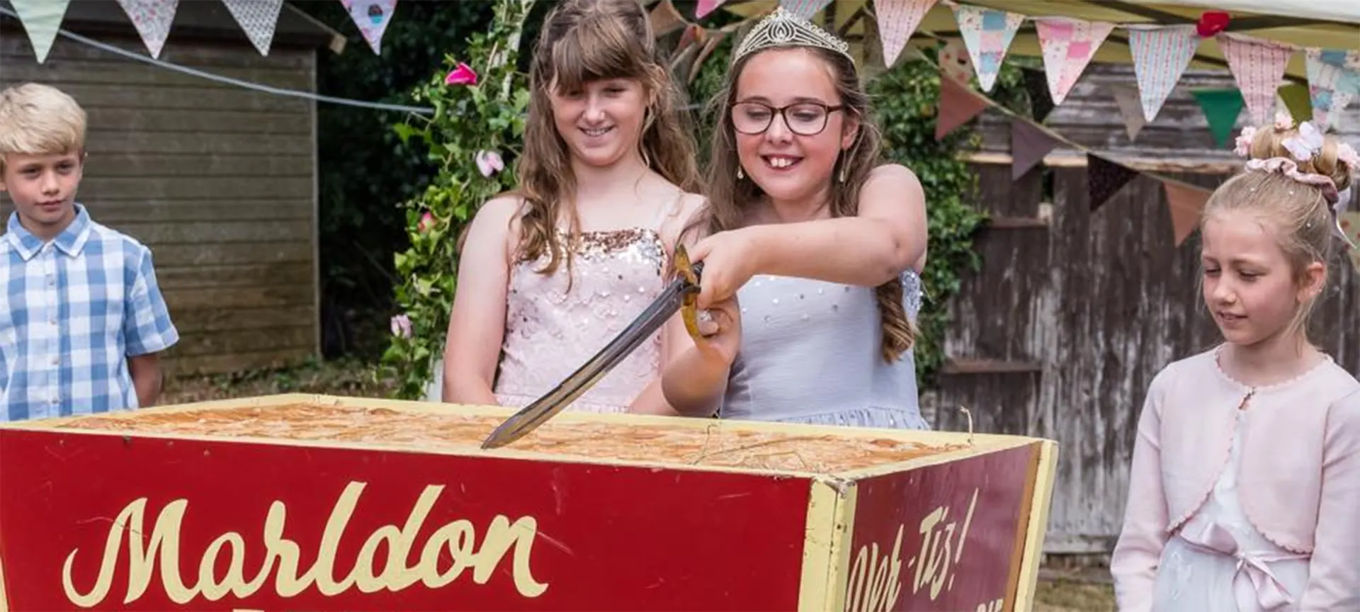 The Marldon Apple Pie Fair has been going since 1888 in memory of local farmer, George Hill, who would use his windfall apples to bake an enormous apple pie for the village. Nowadays, locals and visitors alike join in the celebrations. The opening ceremony includes the official crowning of the Apple Pie Fair Princess (with her Attendants, chosen by ballot from children in their last year at Marldon Primary School. The Opener, helped by the Princess and her Attendants, then cuts the Apple Pie, which is sold with clotted cream by the ladies of the Women's Institute.