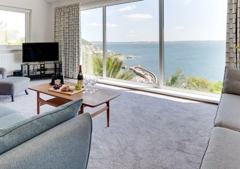 Dolphin Rise, Mousehole is a stunning four-bedroom contemporary retreat boasting panoramic sea views. Enjoy split-level living, modern amenities, and a spectacular large balcony overlooking the harbour, perfect for unforgettable coastal escapes.